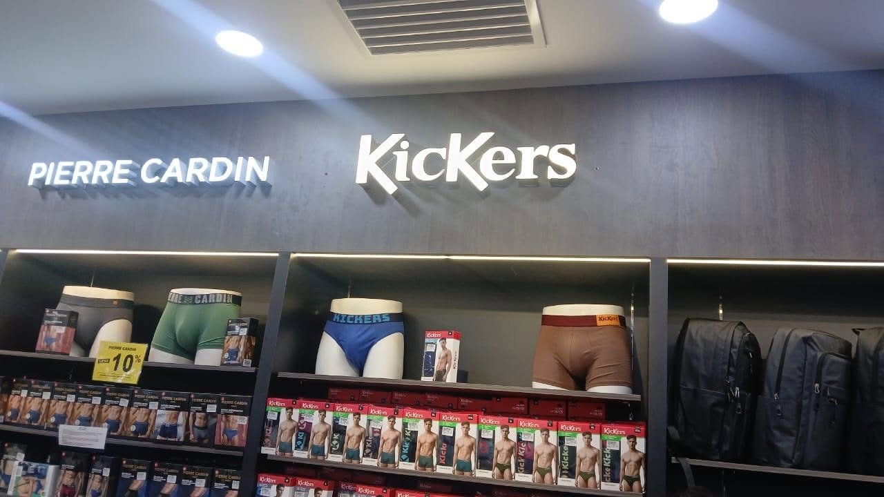 Illuminated retail wall signs above product display shelves